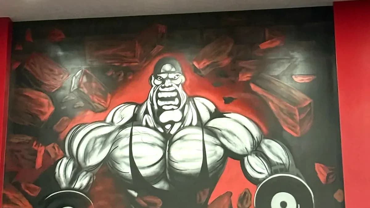 The muscle-man mural on the training floor at Iron Factory Gym